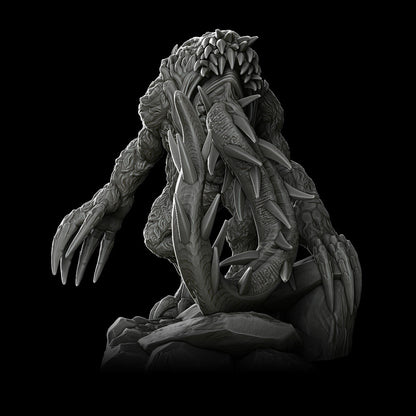 a statue of an alien sitting on a rock