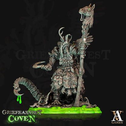 a statue of a demon holding a staff