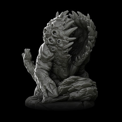 a statue of a demon sitting on a black background